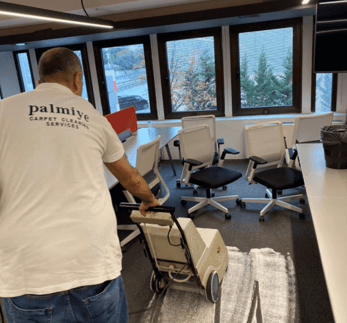 Palmiye Temizlik teknisyeni, ofis halısında kuru köpük halı temizleme makinesi kullanıyor